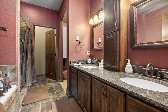 bathroom featuring vanity and independent shower and bath