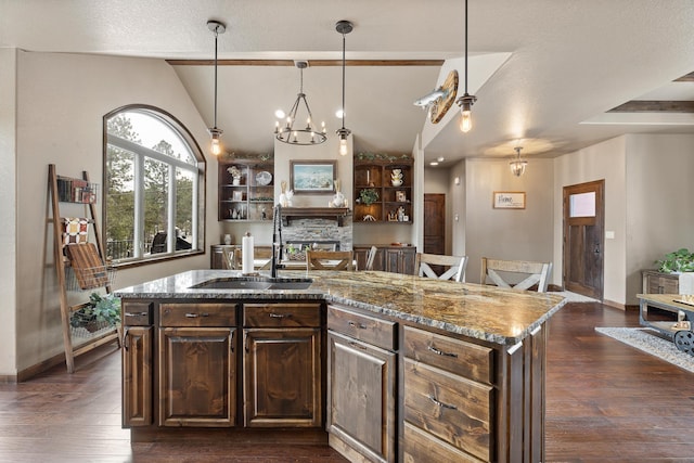 kitchen featuring vaulted ceiling with beams, sink, light stone countertops, a center island with sink, and an inviting chandelier