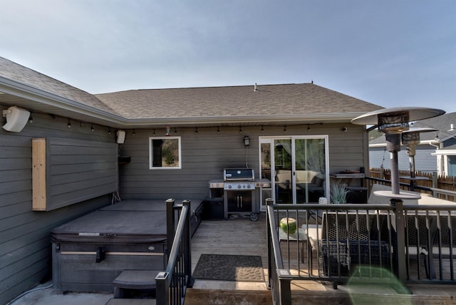 back of property with a deck and a hot tub