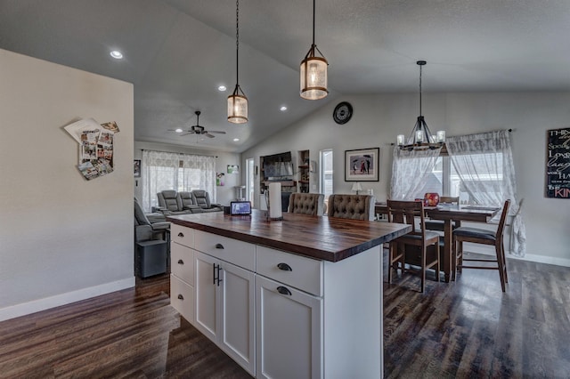 kitchen featuring decorative light fixtures, butcher block countertops, white cabinets, and ceiling fan with notable chandelier