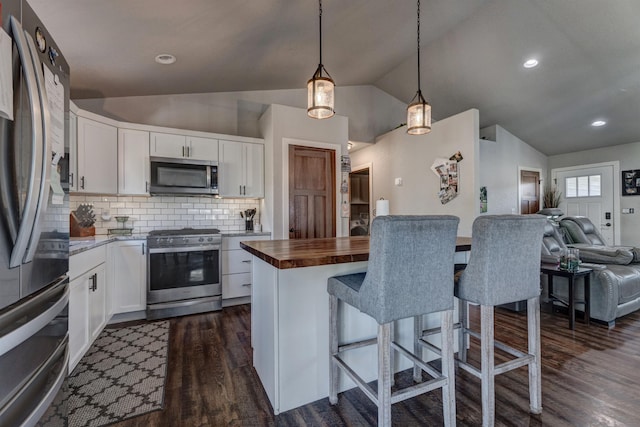 kitchen featuring decorative backsplash, white cabinetry, lofted ceiling, and stainless steel appliances