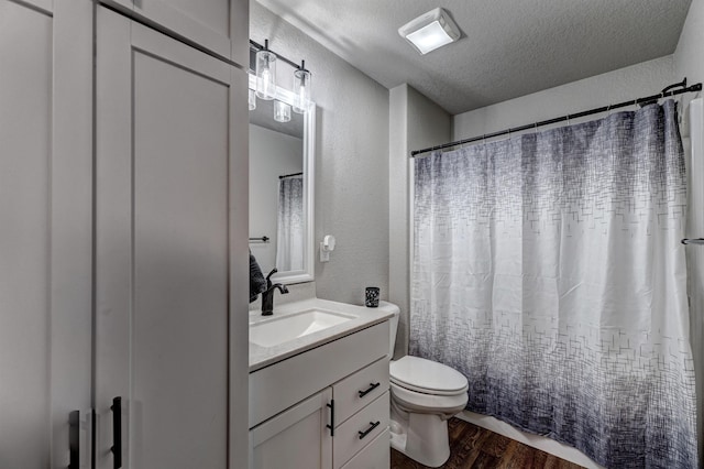 bathroom with a textured ceiling, toilet, wood-type flooring, and vanity