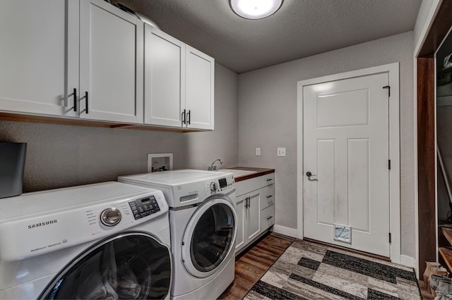 laundry area with a textured ceiling, dark wood-type flooring, cabinets, sink, and independent washer and dryer