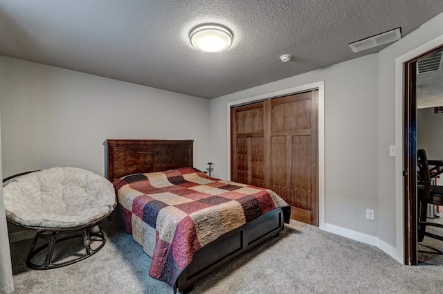 carpeted bedroom featuring a closet and a textured ceiling