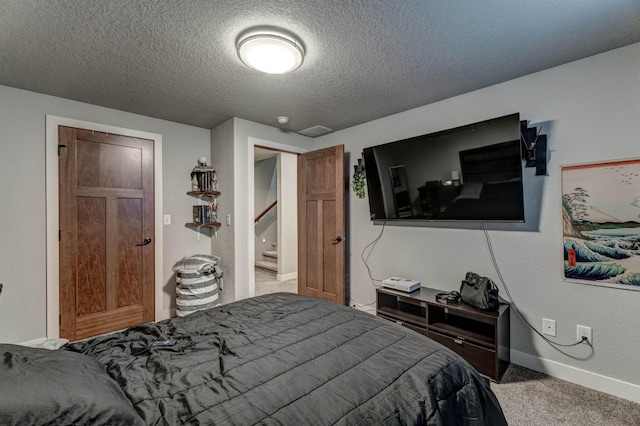 carpeted bedroom featuring a textured ceiling