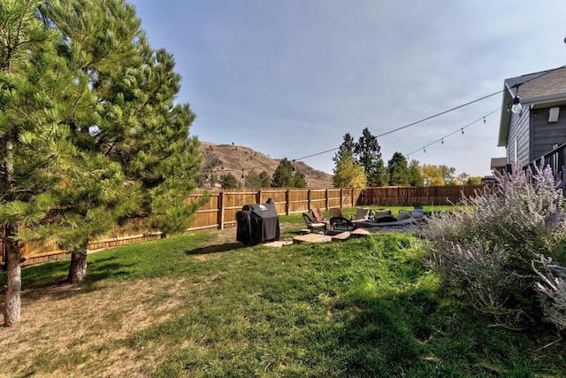 view of yard featuring a mountain view, a fire pit, and a patio