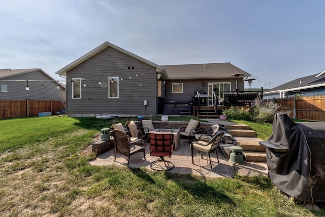 back of house featuring a patio area, a yard, a deck, and a fire pit