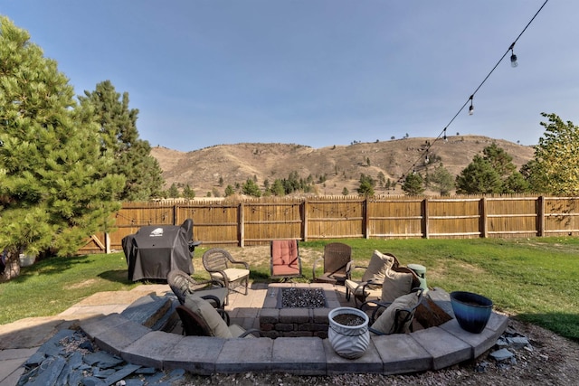 view of yard with a mountain view, a fire pit, and a patio