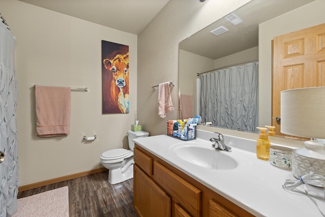 bathroom with toilet, hardwood / wood-style flooring, and vanity