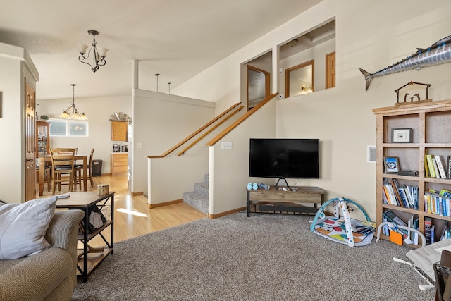 living room with vaulted ceiling, a chandelier, and light hardwood / wood-style floors