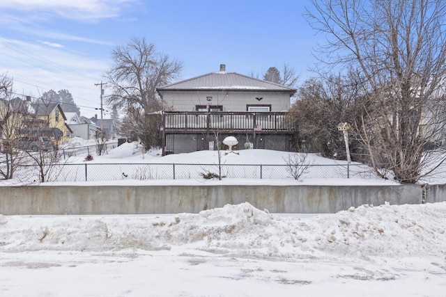 snow covered house featuring a deck