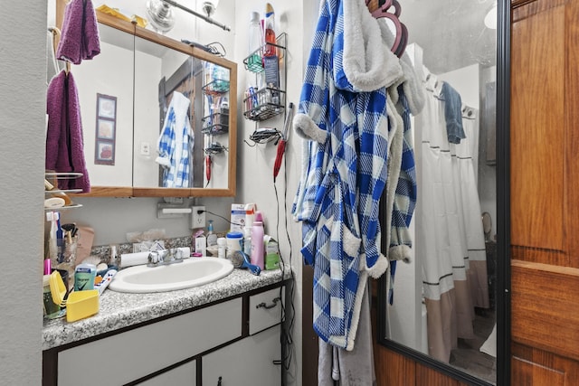 bathroom with walk in shower and vanity