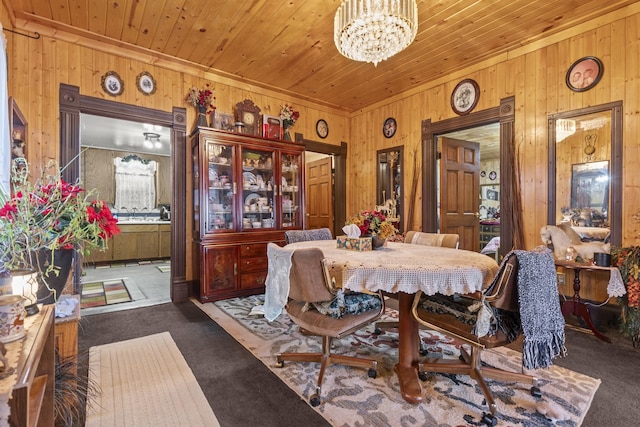 carpeted dining space featuring wooden ceiling, a notable chandelier, and wooden walls