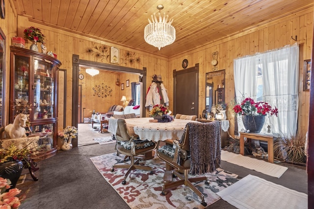 dining area featuring wooden ceiling, wood walls, a notable chandelier, and carpet flooring