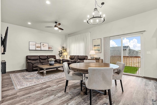 dining room with ceiling fan with notable chandelier and hardwood / wood-style flooring