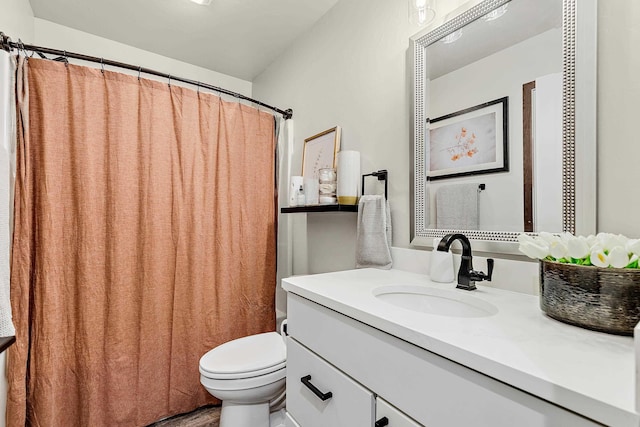 bathroom with toilet, vanity, and curtained shower