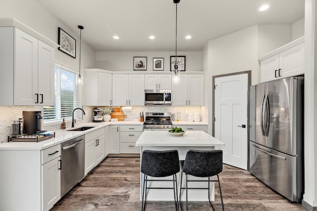 kitchen featuring sink, appliances with stainless steel finishes, pendant lighting, and a center island