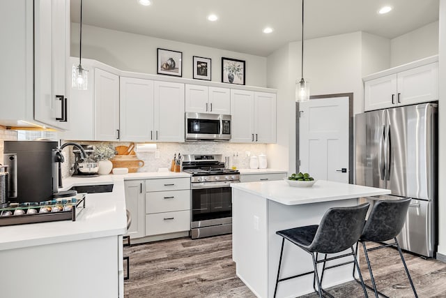 kitchen featuring a kitchen island, decorative backsplash, sink, white cabinetry, and appliances with stainless steel finishes