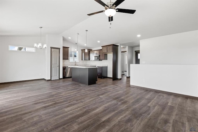 kitchen with lofted ceiling, dark hardwood / wood-style floors, pendant lighting, a kitchen island, and stainless steel appliances