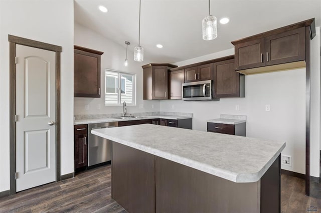 kitchen with a center island, pendant lighting, sink, stainless steel appliances, and dark hardwood / wood-style flooring