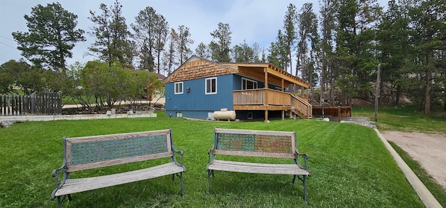 rear view of property with a wooden deck and a yard