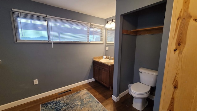 bathroom with vanity, toilet, and hardwood / wood-style floors