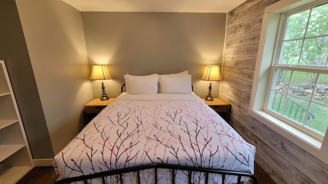 bedroom featuring dark hardwood / wood-style flooring and wood walls