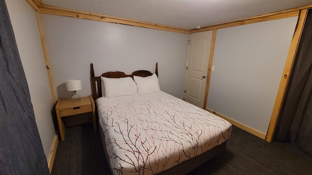 bedroom with dark hardwood / wood-style flooring and crown molding