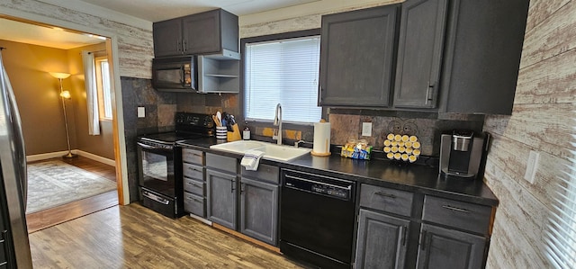 kitchen with black appliances, light hardwood / wood-style flooring, tasteful backsplash, and sink