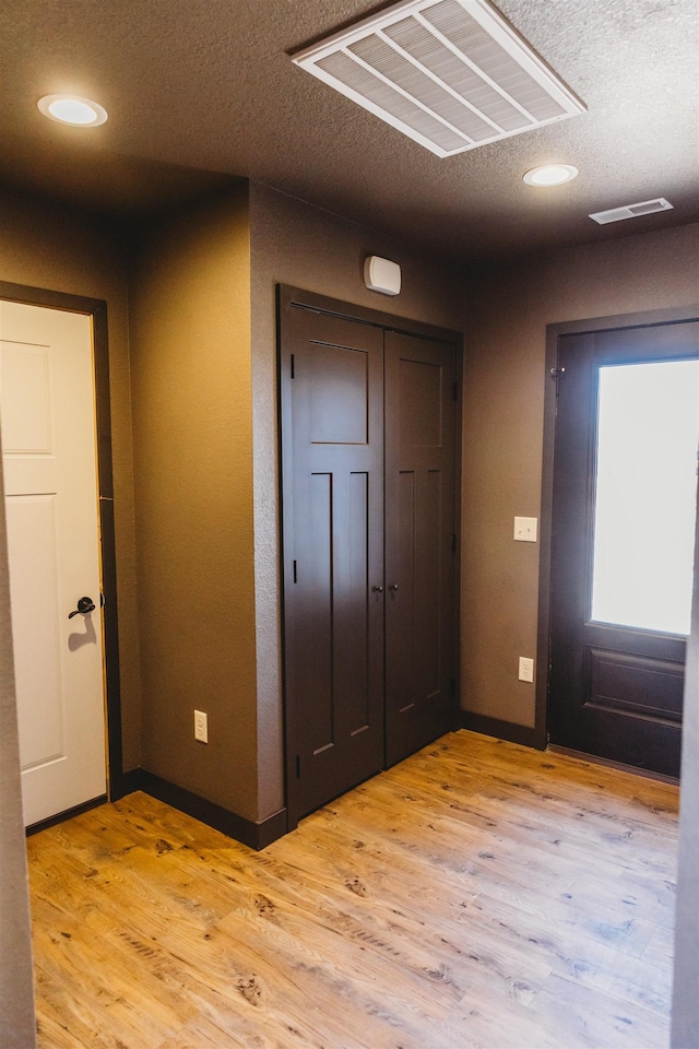 interior space featuring a textured ceiling and light hardwood / wood-style flooring