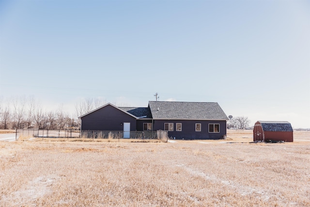 rear view of house with a storage shed