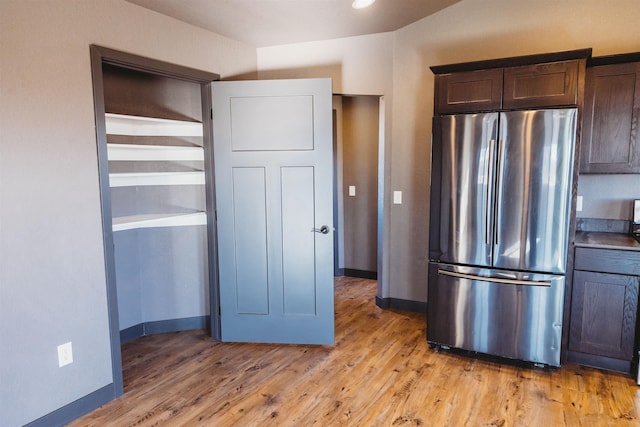 kitchen with light hardwood / wood-style flooring, stainless steel fridge, and dark brown cabinetry