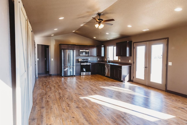 kitchen with light wood-type flooring, dark brown cabinetry, french doors, stainless steel appliances, and lofted ceiling