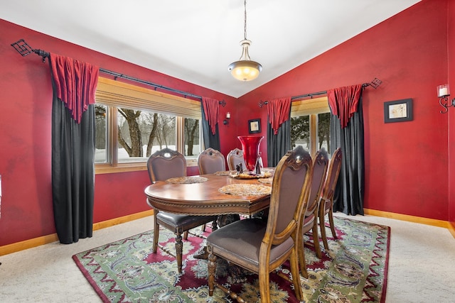 dining room featuring vaulted ceiling and light carpet