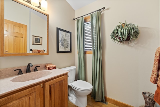 bathroom with vanity, toilet, and hardwood / wood-style floors