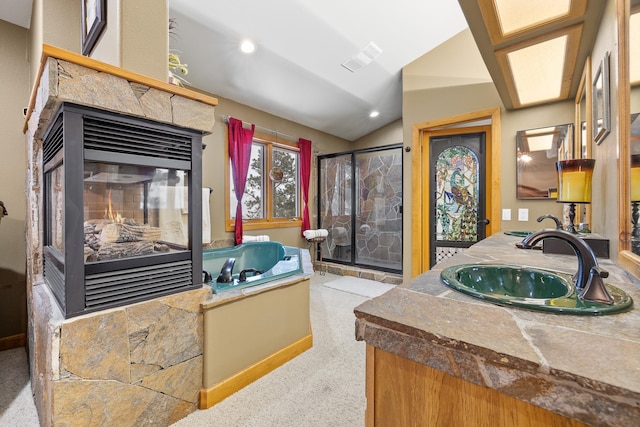 bathroom with a multi sided fireplace, lofted ceiling, a shower with door, and vanity