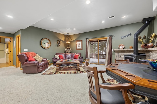 carpeted living room with a wood stove