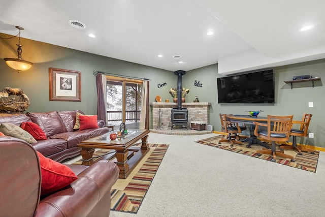 living room featuring carpet floors and a wood stove