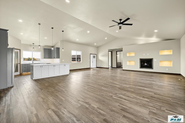 unfurnished living room featuring high vaulted ceiling, wood-type flooring, and ceiling fan