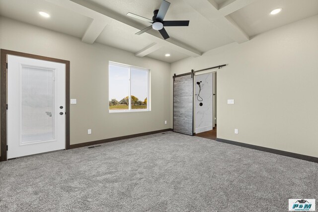 unfurnished bedroom with carpet flooring, beamed ceiling, ceiling fan, and a barn door