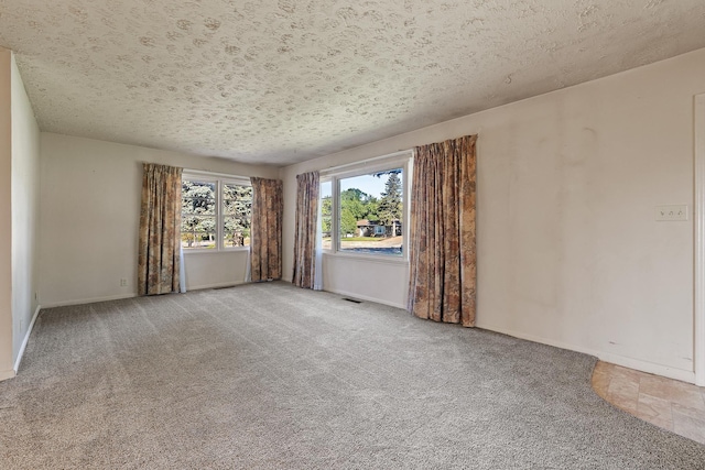 carpeted empty room featuring a textured ceiling