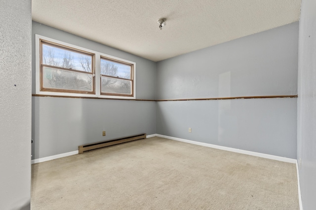 carpeted spare room with a textured ceiling and a baseboard heating unit