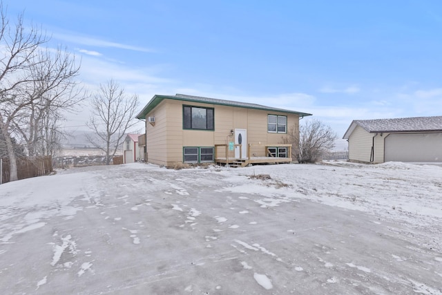 snow covered back of property with a garage