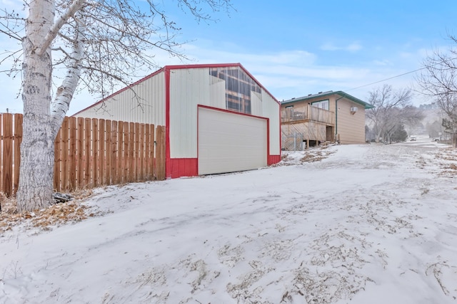 snow covered structure with a garage