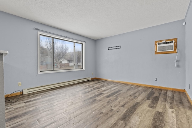 empty room with hardwood / wood-style flooring, a wall mounted air conditioner, a baseboard heating unit, and a textured ceiling