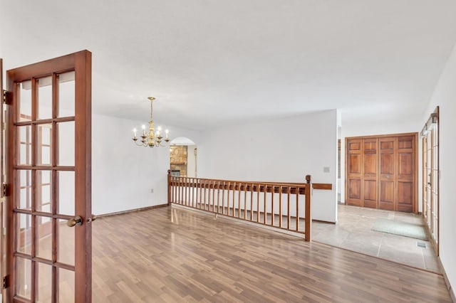 spare room featuring light hardwood / wood-style floors and a chandelier