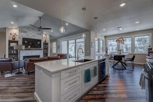 kitchen with white cabinetry, an island with sink, sink, hanging light fixtures, and stainless steel appliances