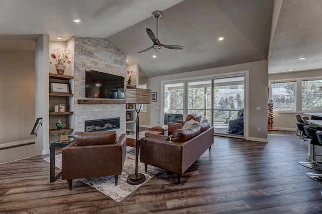 living room with ceiling fan, a large fireplace, dark hardwood / wood-style flooring, and vaulted ceiling