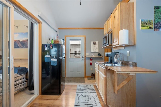 kitchen featuring black refrigerator, sink, light hardwood / wood-style flooring, and light brown cabinets