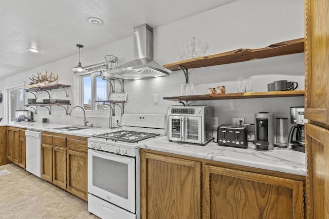 kitchen featuring island range hood, decorative light fixtures, sink, light stone counters, and white appliances